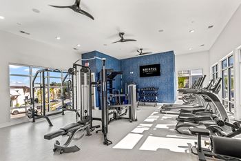 A gym with a row of treadmills and a blue wall with the word 